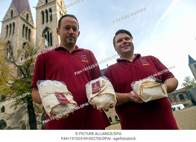 24 October 2019, Saxony-Anhalt, Halberstadt: Peter Potratz (r.) and Mathias Hlady (l.), bakers at the Halberstädter Bäcker and confectioners stand with freshly...