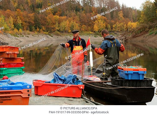 15 October 2019, Saxony-Anhalt, Hasselfelde: Professional fisherman Gernot Quaschny (l) and Sven Ahlendorf fish the small whitefish