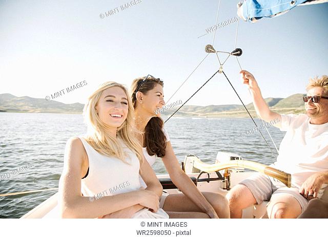 Man, woman and their blond teenage daughter on a sail boat