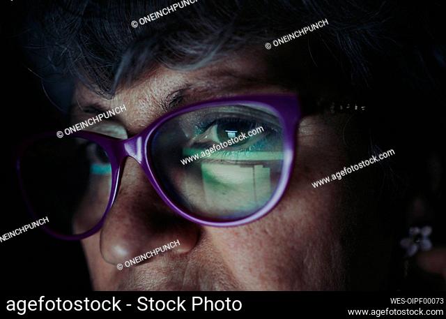 Close-up of senior woman wearing eyeglasses working at home