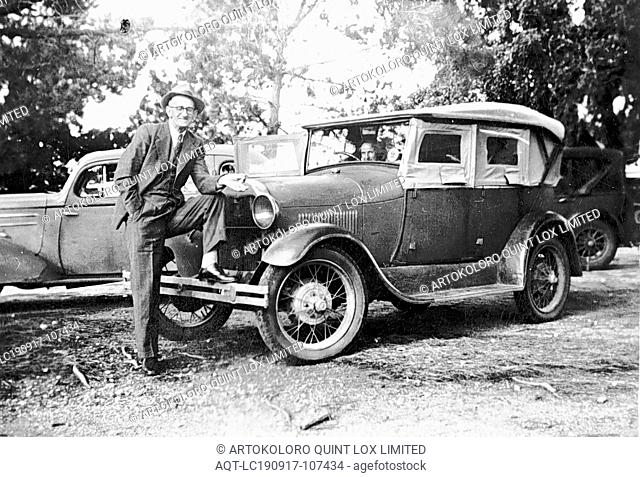 Negative - Man With Model A Ford on Main Street, Avoca, Victoria, circa 1935, A man with his foot on the front bumper of an A Model Ford parked on the median...