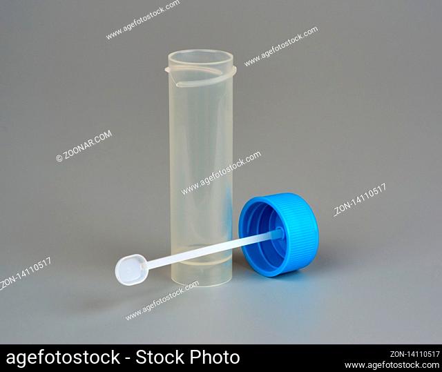 container for biomaterial with spoon on gray background