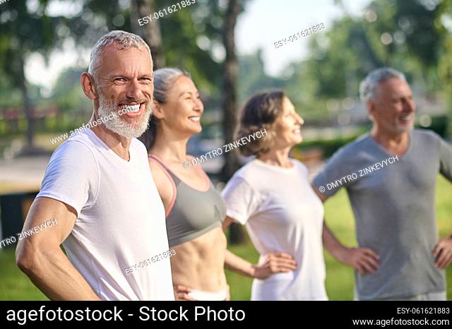Togetherness. A group of mature people in sportswear feeling great together in the park