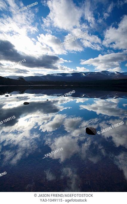 Scotland, Scottish Highlands, Cairngorms National Park  Dramatic clouds and Cairngorm mountains reflected upon the still face of Loch Morlich