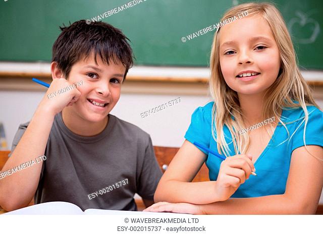 Smiling pupils working together in a classroom