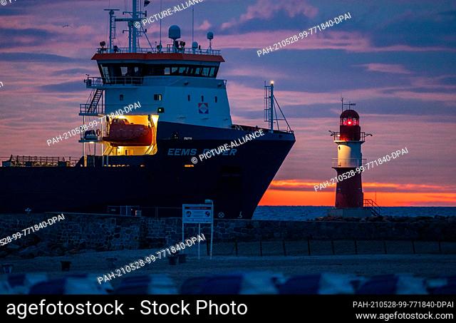 28 May 2021, Mecklenburg-Western Pomerania, Warnemünde: The special ship ""Eems Dover"" enters the seaport of Rostock before sunrise and passes the flashing...