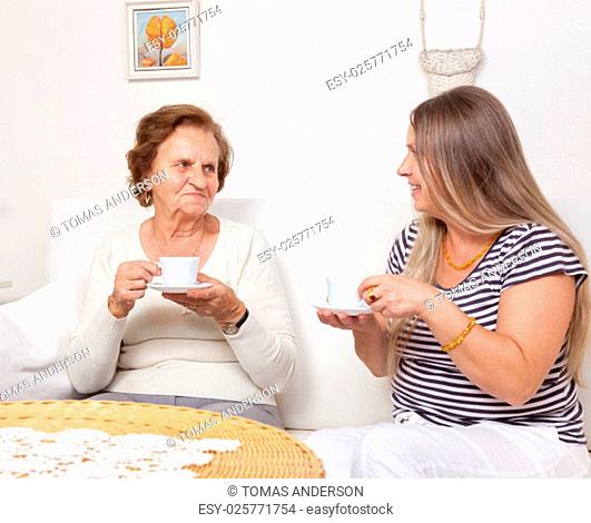 Carer having a cup of tea with an elderly retired woman