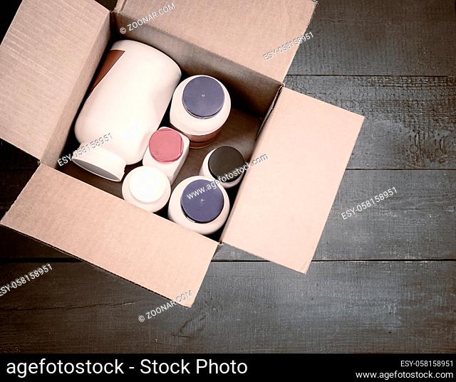 On a wooden table in a cardboard box bottles with medicines and cosmetics to send to the buyer