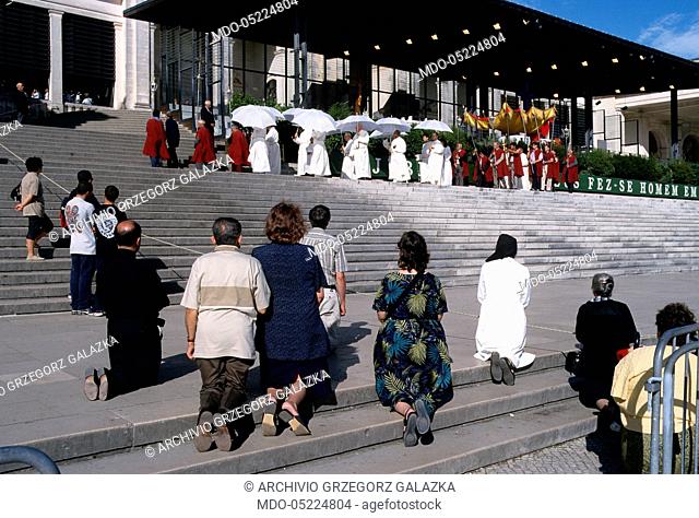 Pilgrims kneeling during the procession with the Blessed Sacrament in front of the Basilica of Our Lady of the Rosary. Fatima, Portugal. 2nd July 2000