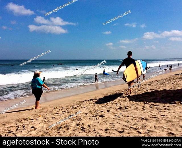 FILED - 01 June 2019, Indonesia, Kuta: Surfers and tourists walk along the famous Kuta Beach. The island hopes for a revival of the important tourism soon