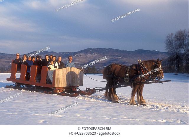 open sleigh ride, Stowe, Vermont, VT, A team of horses pulls a red sleigh full of people through the snow covered field at Trapp Family Lodge in Stowe