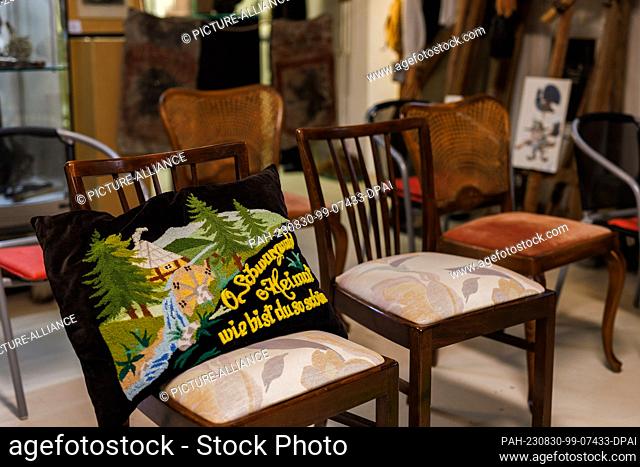 PRODUCTION - 28 August 2023, Baden-Württemberg, Münstertal: A cushion with the inscription ""O Black Forest homeland how are you so beautiful"" lies on a chair...