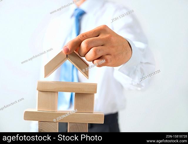 Close up of businessman building tower of wooden blocks