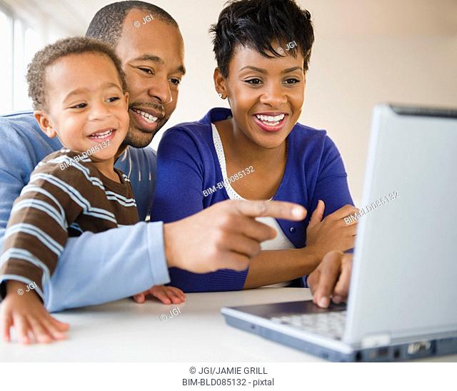 Black family using laptop together