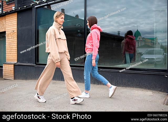 Two girls walking on the city street. Young woman outdoors