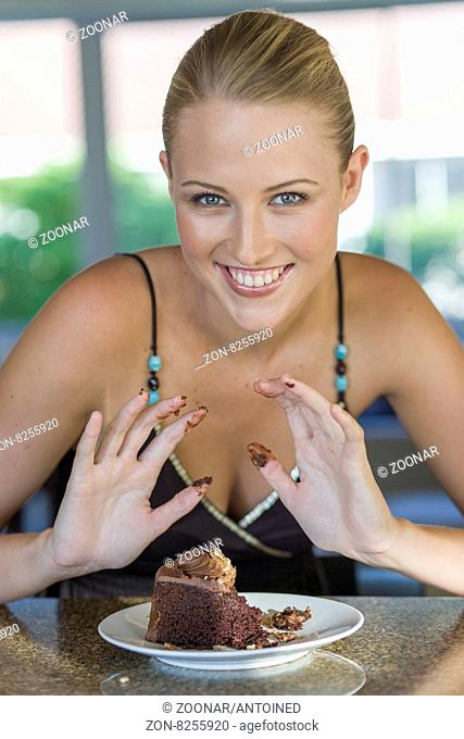 Young blond woman enjoying chocolate cake