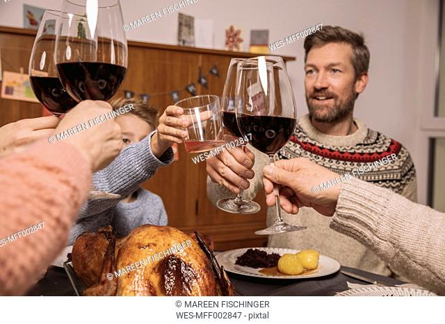 Family clinking glasses during Christmas dinner