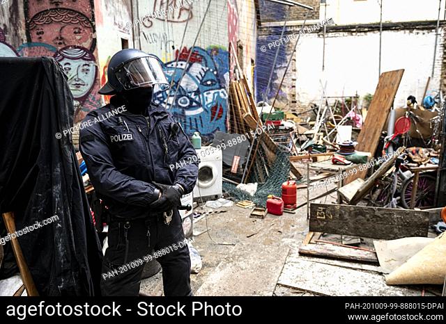 09 October 2020, Berlin: After the eviction, a policeman stands in the courtyard of the formerly occupied house ""Liebig 34""