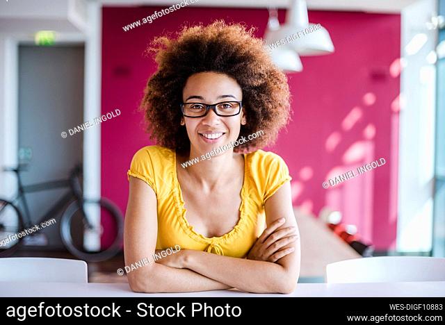 Young woman working in modern office, looking at camera