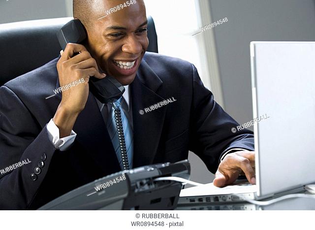 Close-up of a businessman smiling and talking on the phone