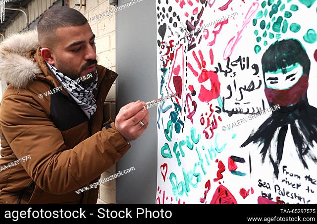 RUSSIA, MOSCOW - NOVEMBER 28, 2023: A man wearing a Palestinian keffiyeh writes a message outside the Palestinian Embassy on the International Day of Solidarity...