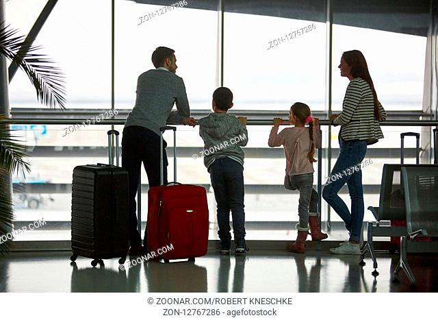 Familie macht Urlaub zusammen und wartet im Flughafen Terminal auf den Anschlussflug