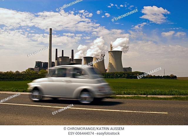 white vintage car drives past the Neurath power plant
