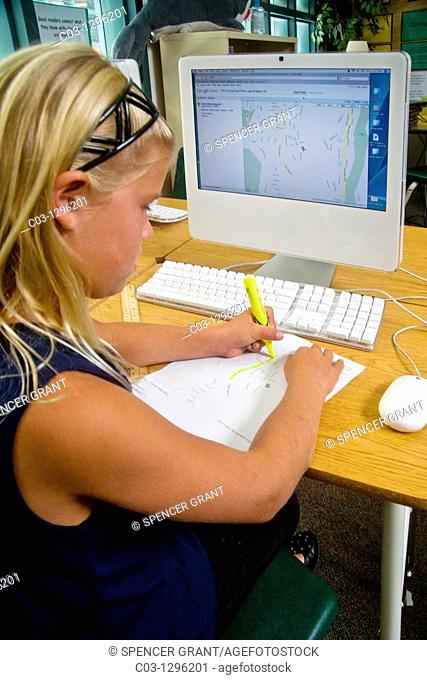 A school girl draws major neighborhood routes on a map downloaded from a computer in San Clemente, CA