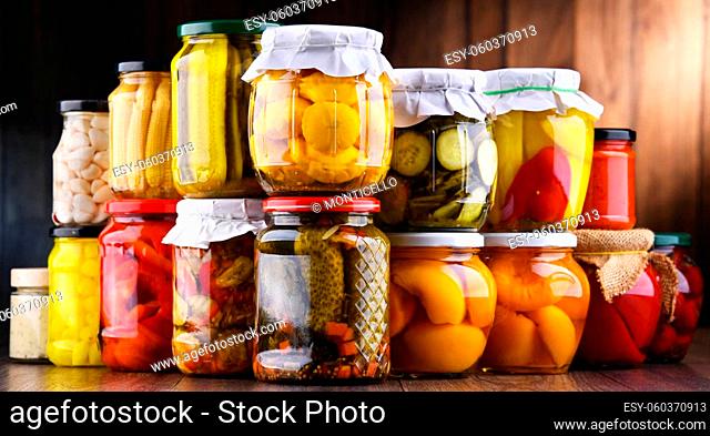 Jars with variety of marinated vegetables and fruits. Preserved food