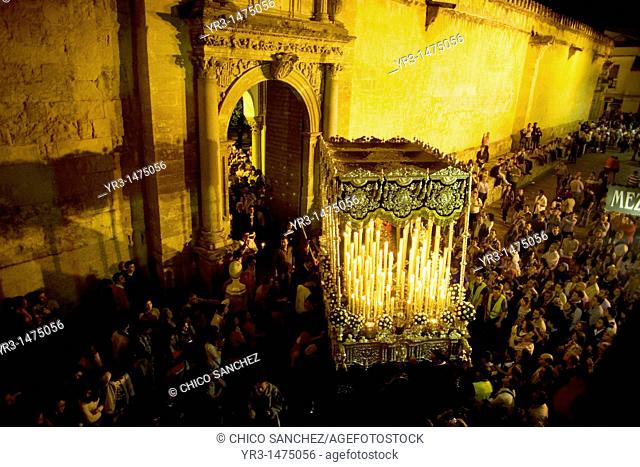 A throne displaying a Virgin Mary sculpture is carried through a doorway of the Mosque-Cathedral of Cordoba during an Easter Holy Week procession in Cordoba