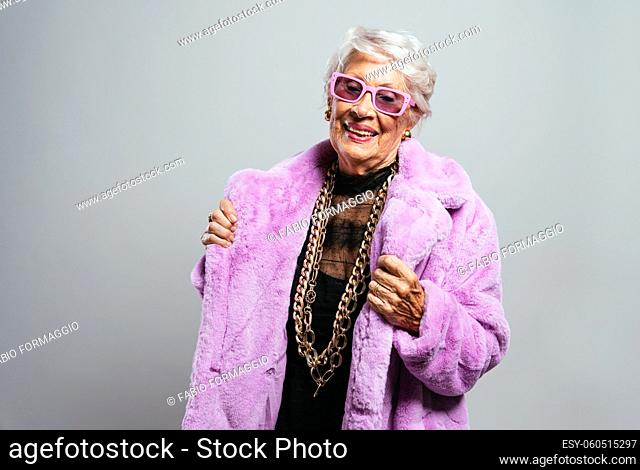 image of a beautiful and elegant old influencer woman. Cool grandmother posing in studio wearing fashionable clothes. Happy senior lady celebrating and making...