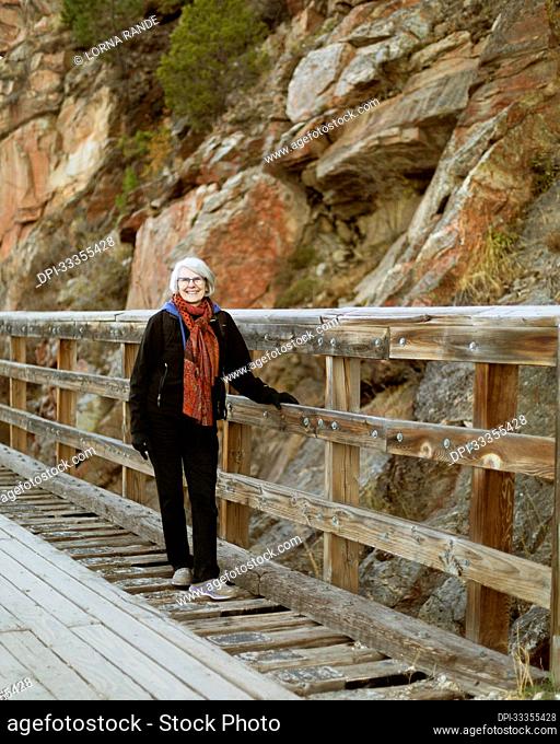 A woman stands on a restored train trestle bridge in Myra Canyon; Kelowna, British Columbia, Canada