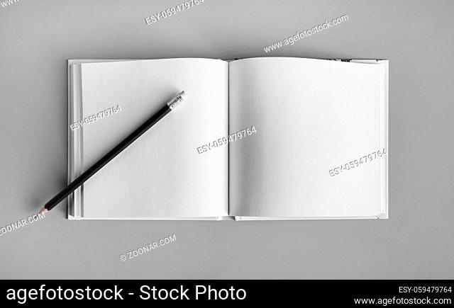 Blank sketchbook and pencil mock up on gray paper background. Top view. Flat lay