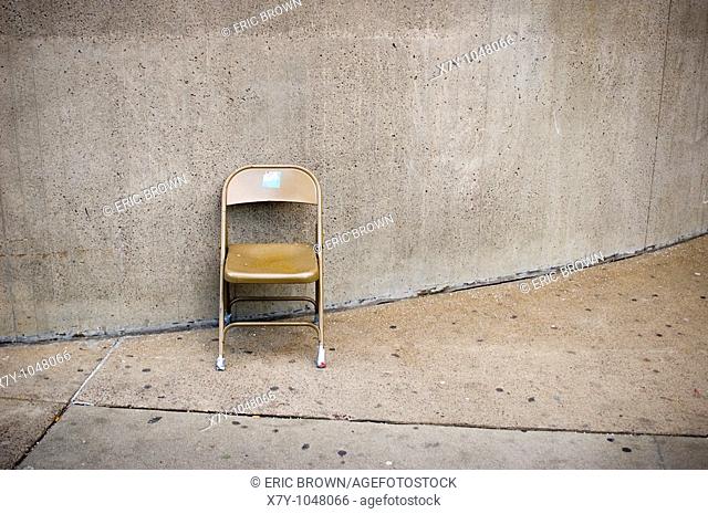 A folding chair sits against a wall