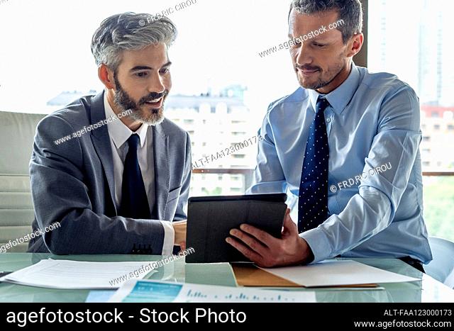Businessmen looking at digital tablet