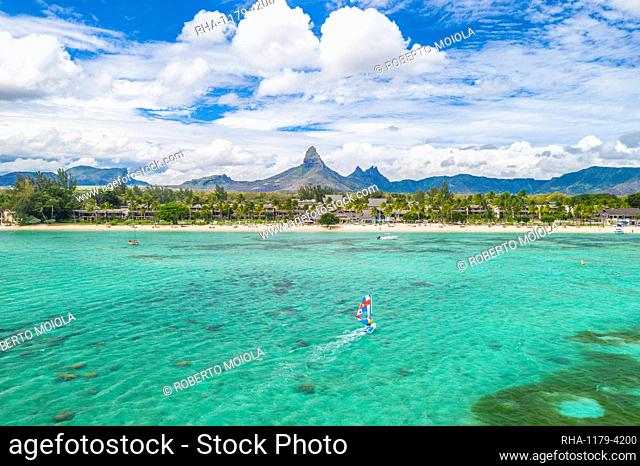 Aerial view by drone of windsurfer in the lagoon facing Flic en Flac beach and Piton de la Petite Riviere Noire mountain, Black River, Mauritius, Indian Ocean