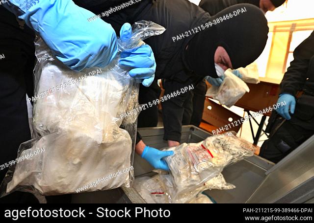 14 December 2021, Bavaria, ---: Bavarian riot police officers prepare bags of cocaine for removal. As part of Operation Snowmelt
