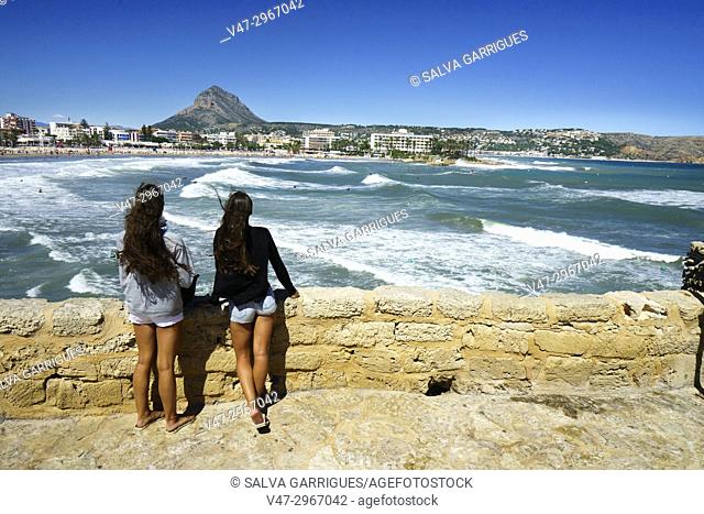 Two girls watching the waves on the beach of El Arenal in Javea, Alicante, Valencia, Spain, Europe