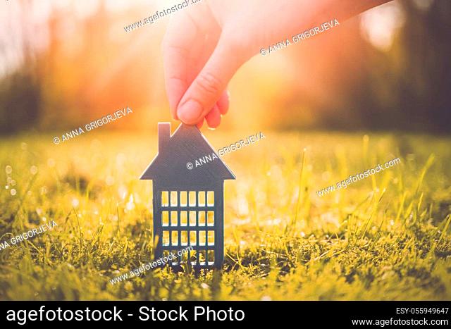 Model of gray apartment house on autumn yellow grass on a sunny day. Conceptual symbol of renting, hostel and student housing