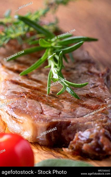 Gegrilltes Steak auf Holz mit Gewürzen