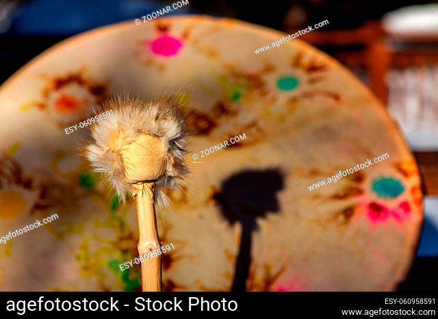 A close-up view of a sacred drum and drumstick, traditionally used by Native American tribes for spiritual ceremonies. Traditional percussion instrument