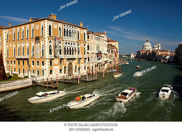 View of boats on the Grand Canal from Ponte dell'Accademia bridge with Palazzo Cavalli-Franchetti in the foreground and Santa Maria della Salute in the distance...