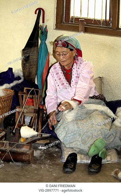 NEPAL, PATAN, 07.12.2011, An elderly Tibetan woman spins Himalayan yak wool on a small spinning wheel at the Tibetan Refugee Centre in Patan, Nepal