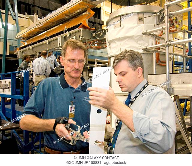 Astronaut Joseph R. Tanner, left, works with David H. Mothers of USA on possible ISS solar array repair procedures to be used by STS-120 spacewalkers