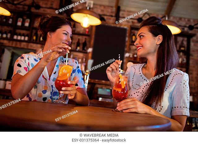 Two young women having cocktail drinks