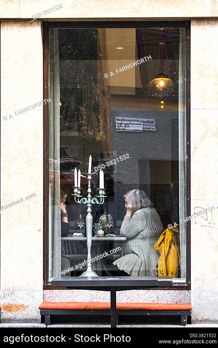 Stockholm, Sweden Two senior women sitting in the window of a pizza restaurant in Midsommarkransen