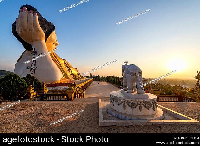 Myanmar, Mon State, Giant statue of reclining Buddha in Pupawadoy Monastery at sunset