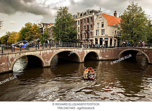 A boat passes the Hemonybrug bridge at Keizersgracht and Leidsegracht in the Singel Canel in Amsterdam