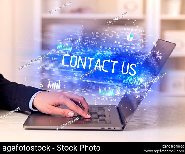Closeup of businessman hands working on laptop with CONTACT US inscription, succesfull business concept