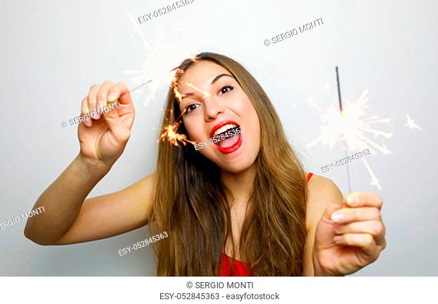 Happy cheerful girl holding bengal lights at party. Portrait of young woman celebrating with sparklers isolated on white background